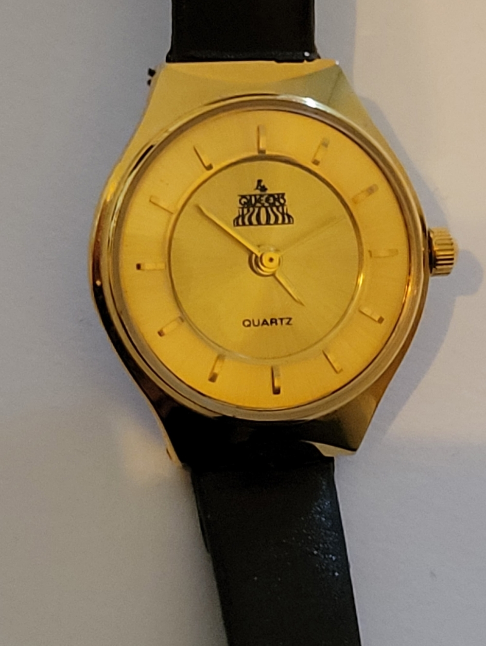 Quartz Watch Featuring A Gold Tone Face With Black Leather Band
